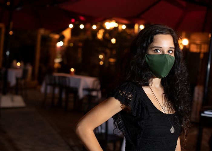 Woman wearing mask outdoors at restaurant