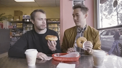 Two men "clinking" donuts together as a toast