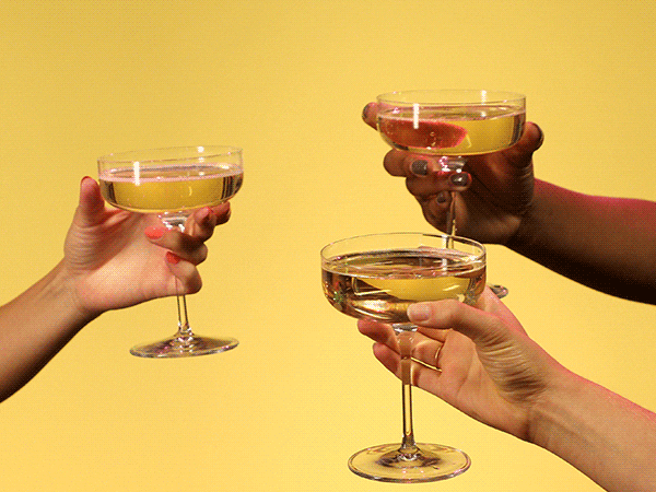three people clinking glasses together in a toast