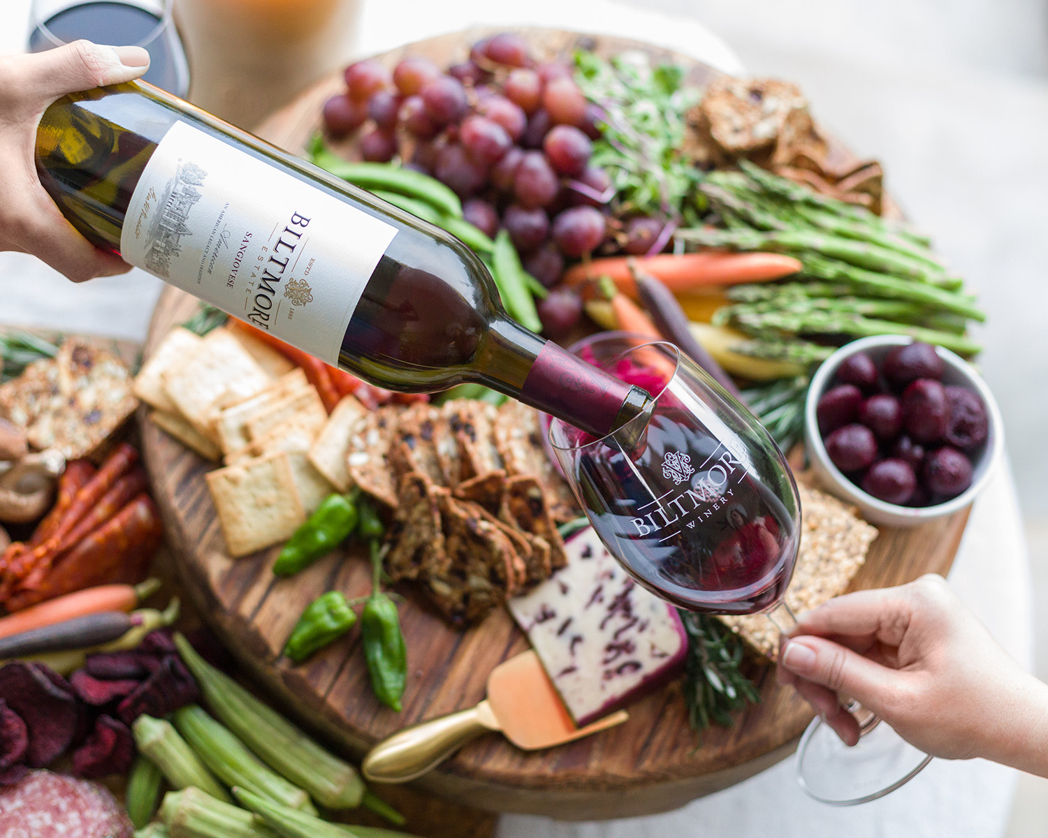 Biltmore wine being poured over a charcuterie board.