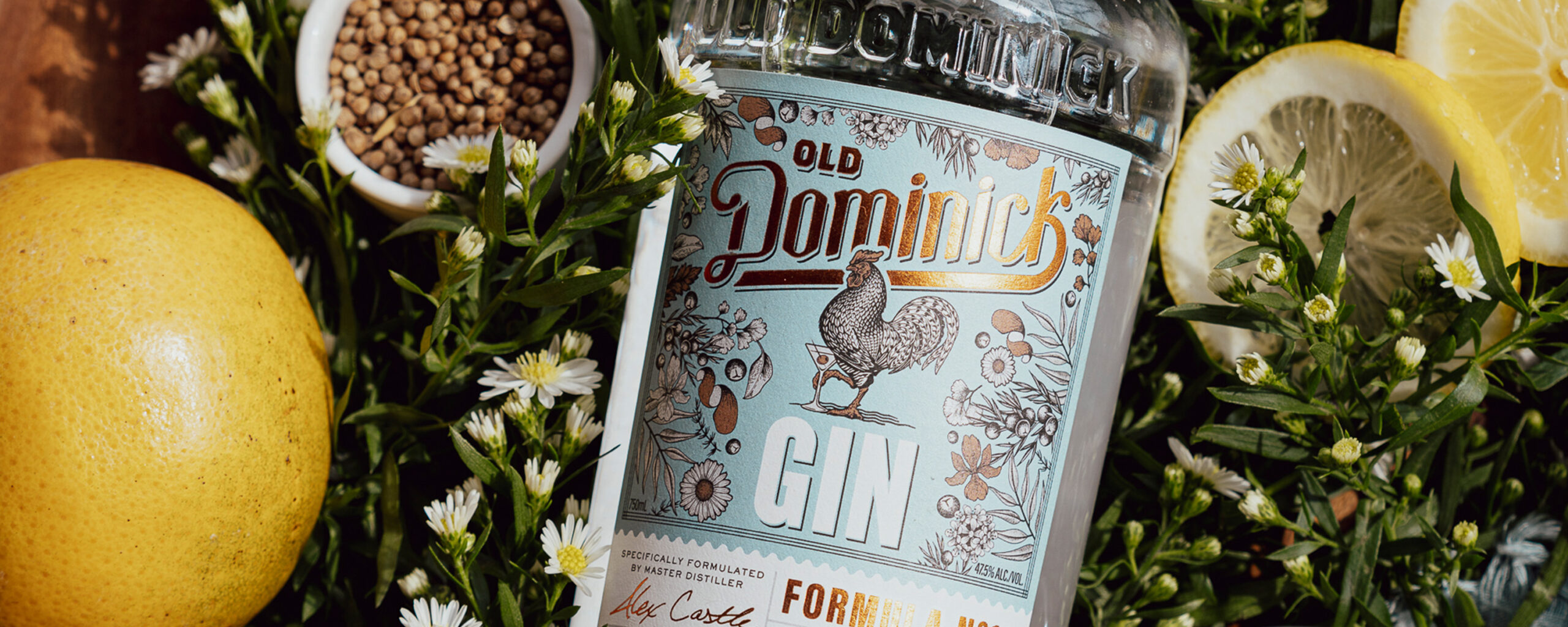 Bottle of ODD gin nestled into greenery and lemons.