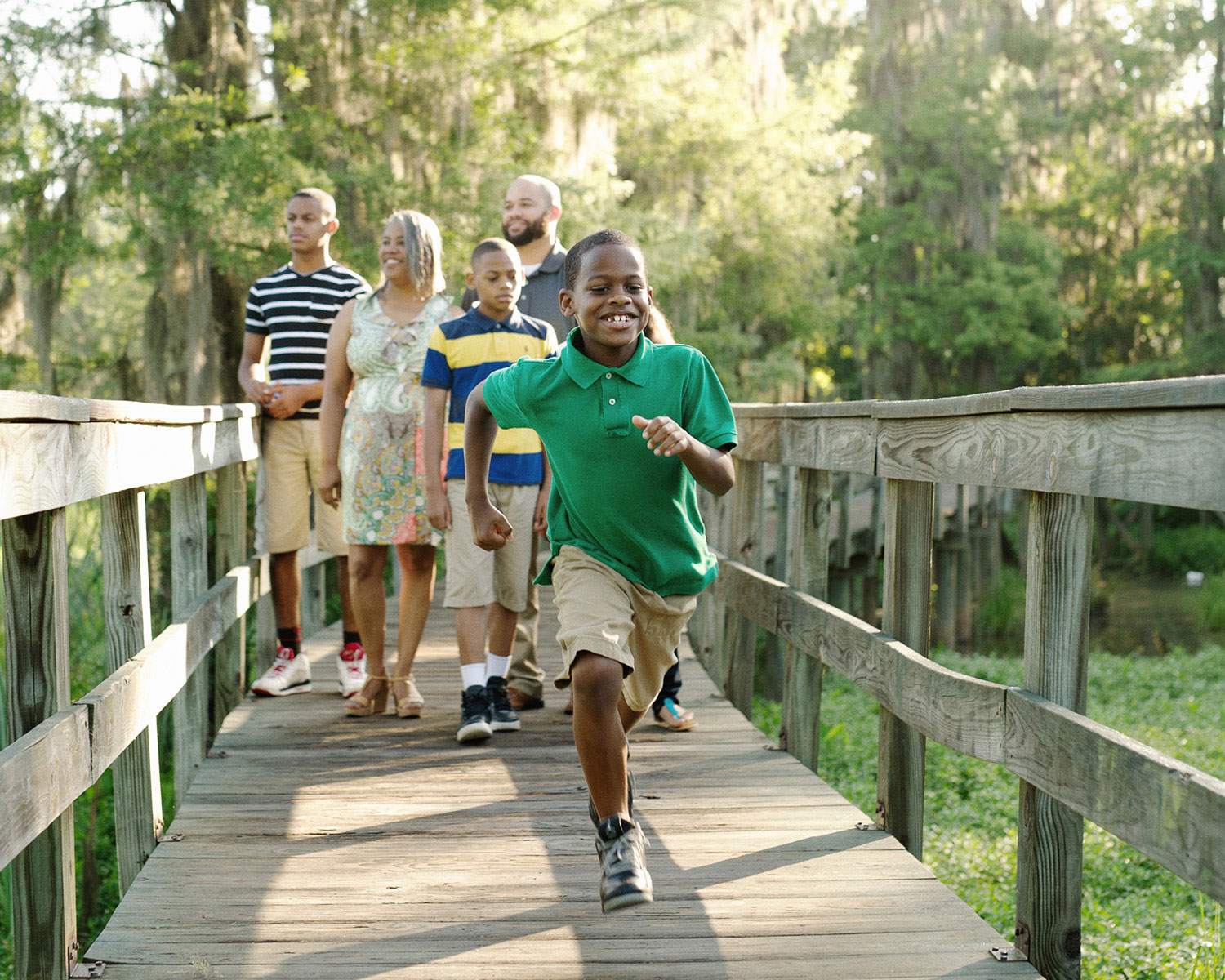 Family walking across a wooden bridge.