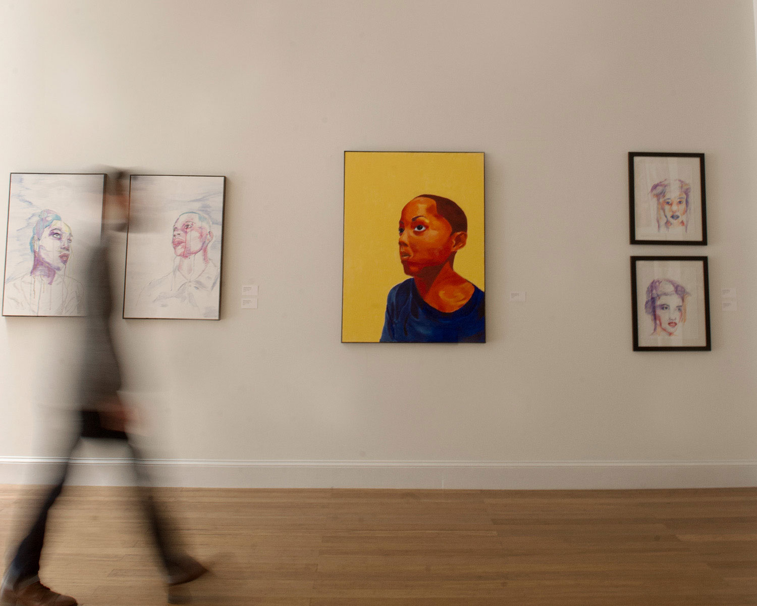 Person walking through an art gallery.